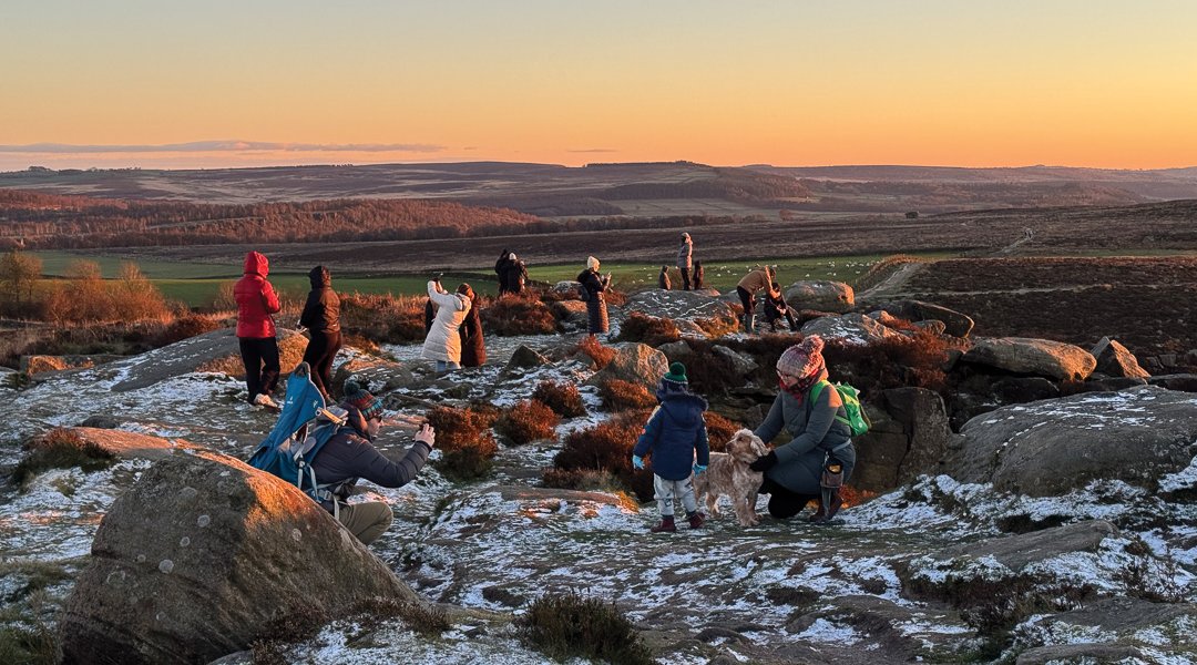 People gather to photograph the sunset at Curbar Edge
