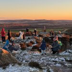 People gather to photograph the sunset at Curbar Edge