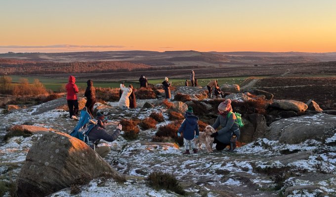 People gather to photograph the sunset at Curbar Edge