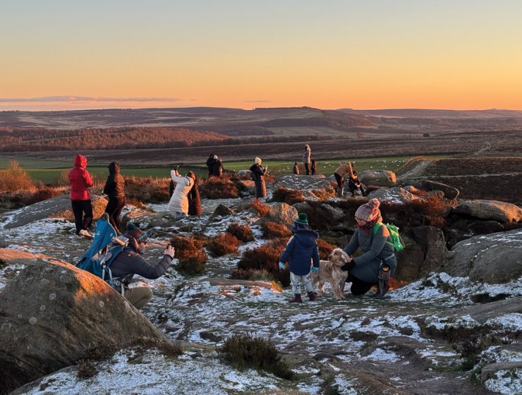People gather to photograph the sunset at Curbar Edge