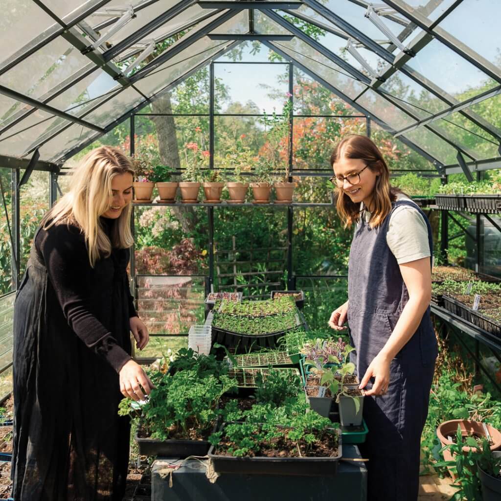 Vicky (left) and Megan at work in their greenhouse. Picture: Helen Rowan Photography