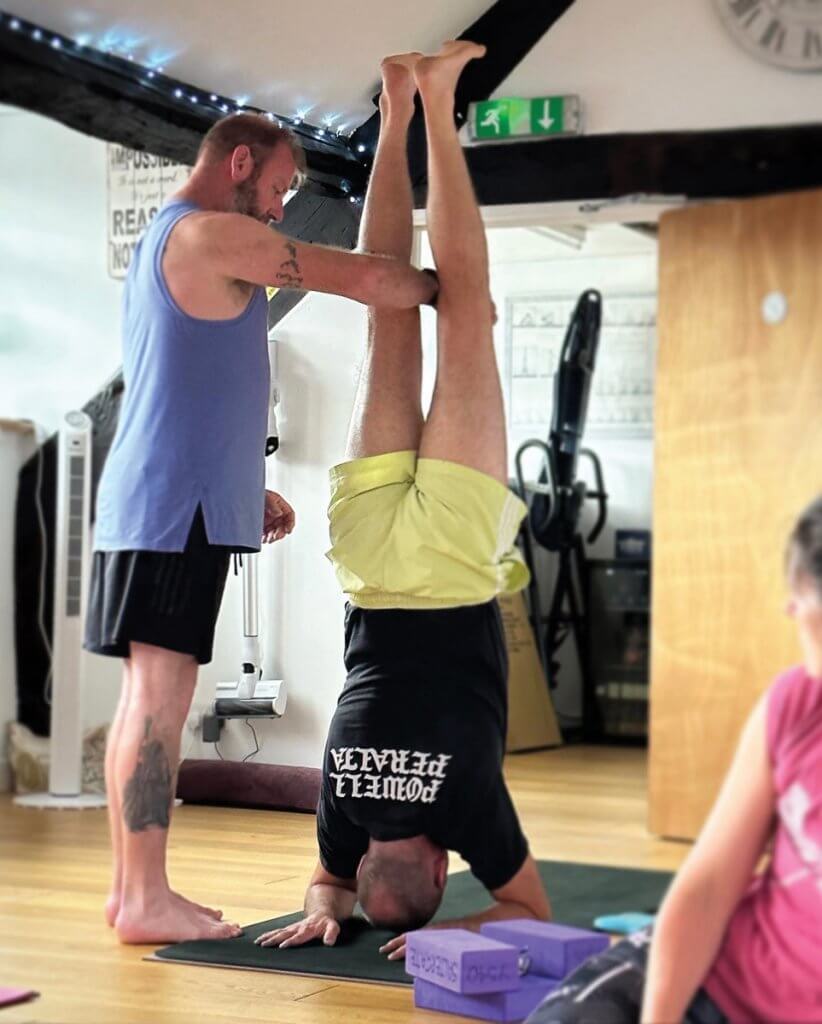 Colin assists a forearm balance. Picture: Saltergate Yoga