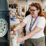 A volunteer arranges homewares to tempt shoppers